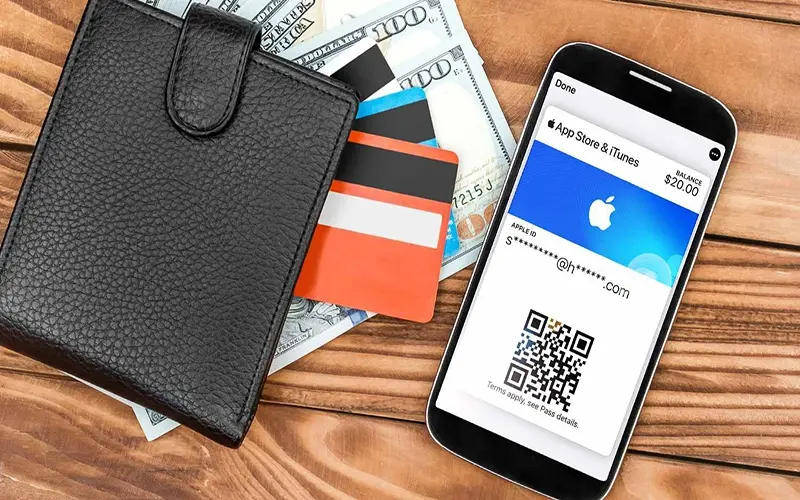 An iphone with app store and itunes on its screen lying beside a wallet and dollar bills - تصویر 3